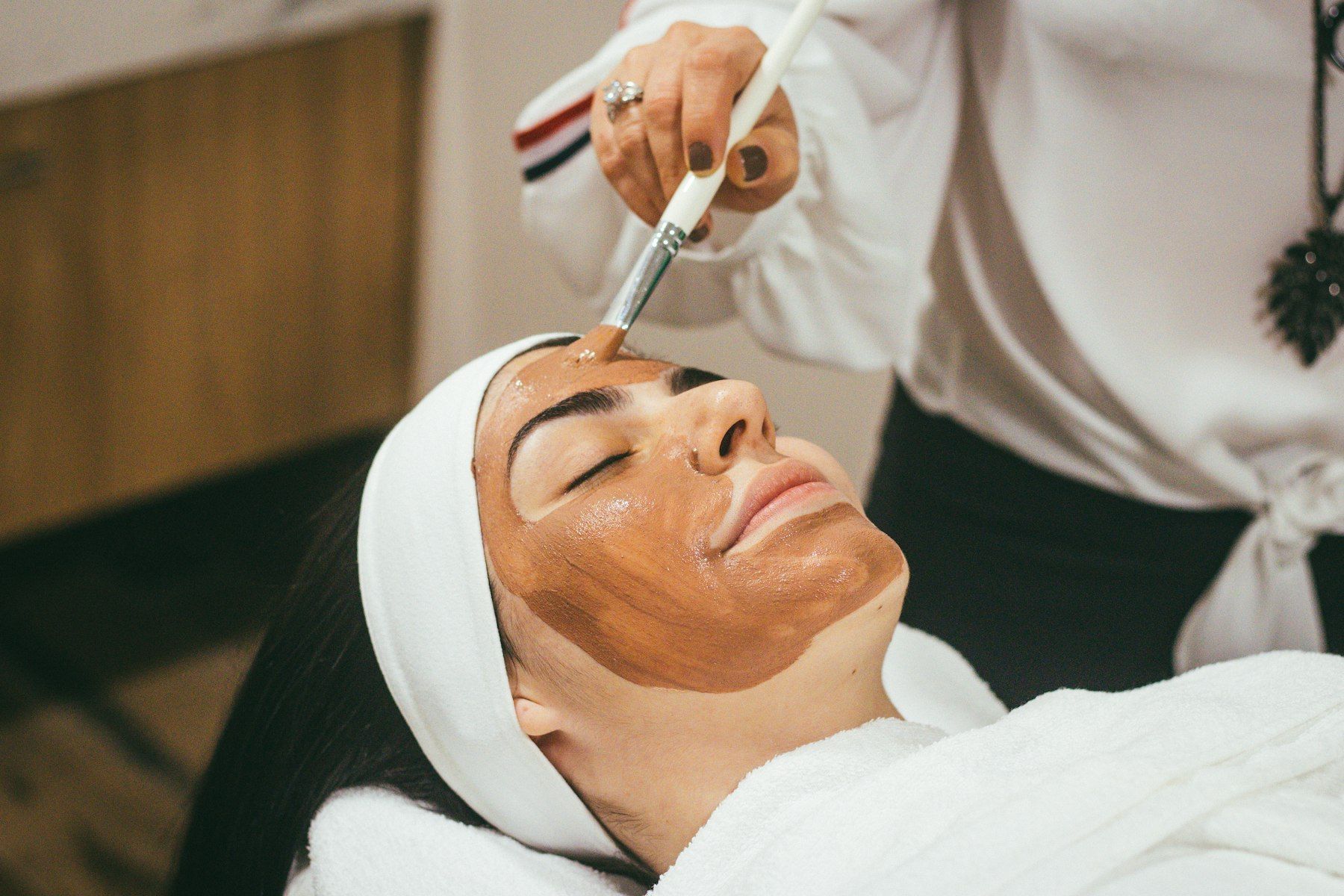 Cosmetóloga aplicando mascarilla facial